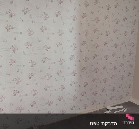 קיר עם טפט פרחוני ורוד על רקע לבן